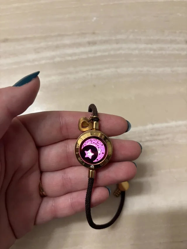 Community product photo: a brown Moon touch bracelet glowing pink in a customer’s hand