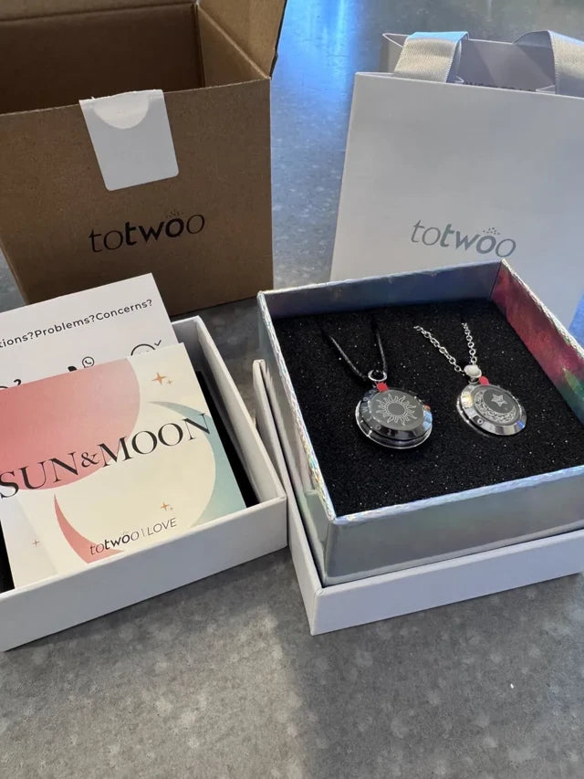 Jeweliet C.’s Sun and Moon necklace review photo, showing both necklaces with their gift packaging