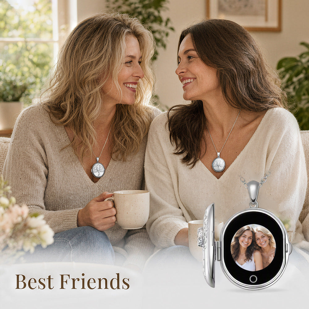Two women sitting together indoors, both wearing matching silver pendant necklaces with round medallions. digital locket necklace  is shown open in the foreground with a photo displayed inside, and the text 'Best Friends' appears at the bottom.